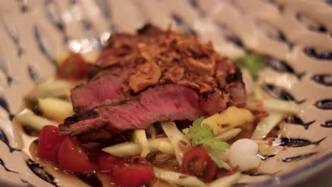 sliced steak served with vegetables and garnish