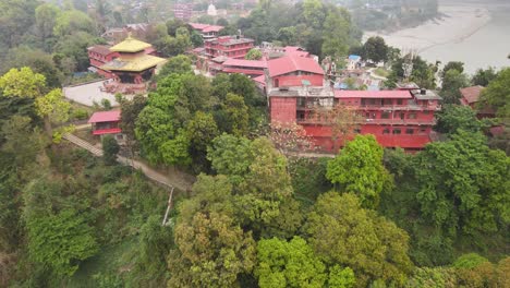 stunning drone view of devdaha temple in chitwan, nepal, nestled in lush greenery and traditional village life. captures sacred architecture amid peaceful rural surroundings from above