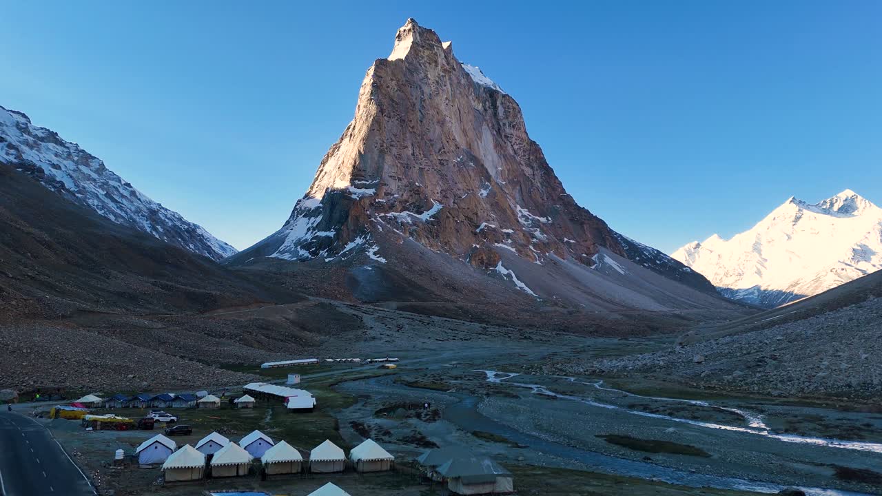 Aerial drone shot showing the gradual brightening of Gumbok Rangan mountain during sunrise.