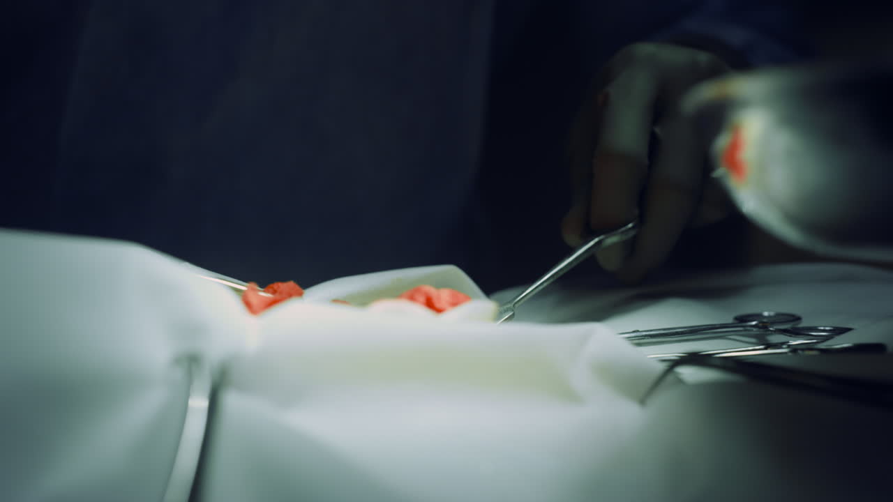 las manos del cirujano operan en la sala estéril de la clínica. el equipo médico coopera.