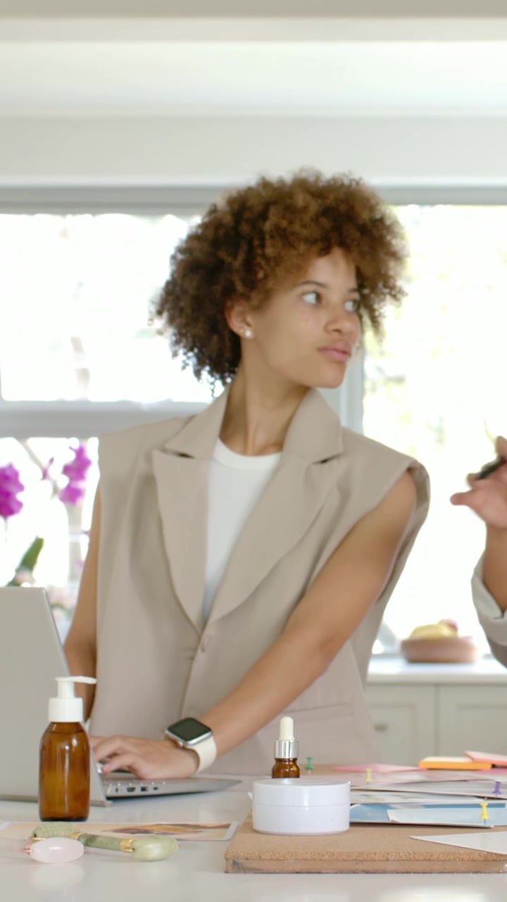 Vertical video: Reacting to pen pointing, woman in blazer typing and checking laptop at desk