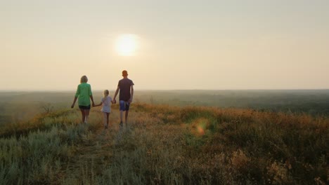 Eine-Familie-Mit-Einem-Kind-Geht-Der-Sonne-Entgegen