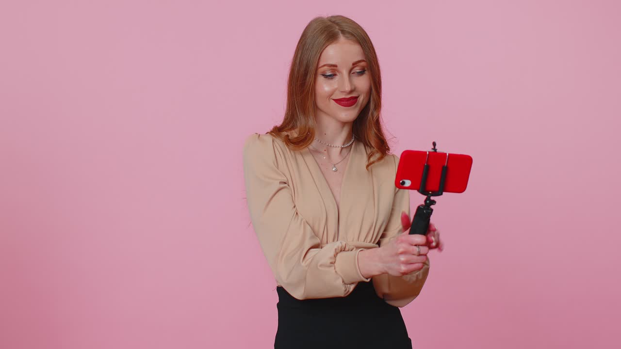 Adult girl blogger taking selfie on mobile phone communicating video call online with subscribers