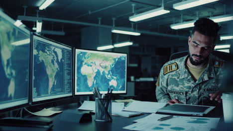 soldier analyzing data in a high-tech control room