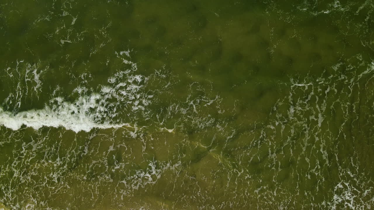 olas de mar oscuro salpicando en la orilla en wladyslawowo, región de pomerelia, polonia - drone aéreo, de arriba hacia abajo