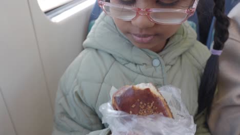 niño comiendo un pastel en el transporte público