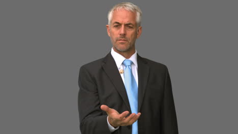 elegante hombre de negocios lanzando un dado en el aire en la pantalla gris