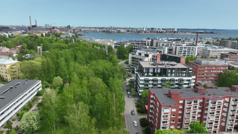 AERIAL:-spring-colored-trees-and-quiet-streets,-in-sunny-Lauttasaari,-Helsinki