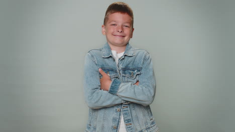 vrolijk knappe peuter jonge jongen modemodel in jeans jas glimlachend, alleen naar de camera kijkend
