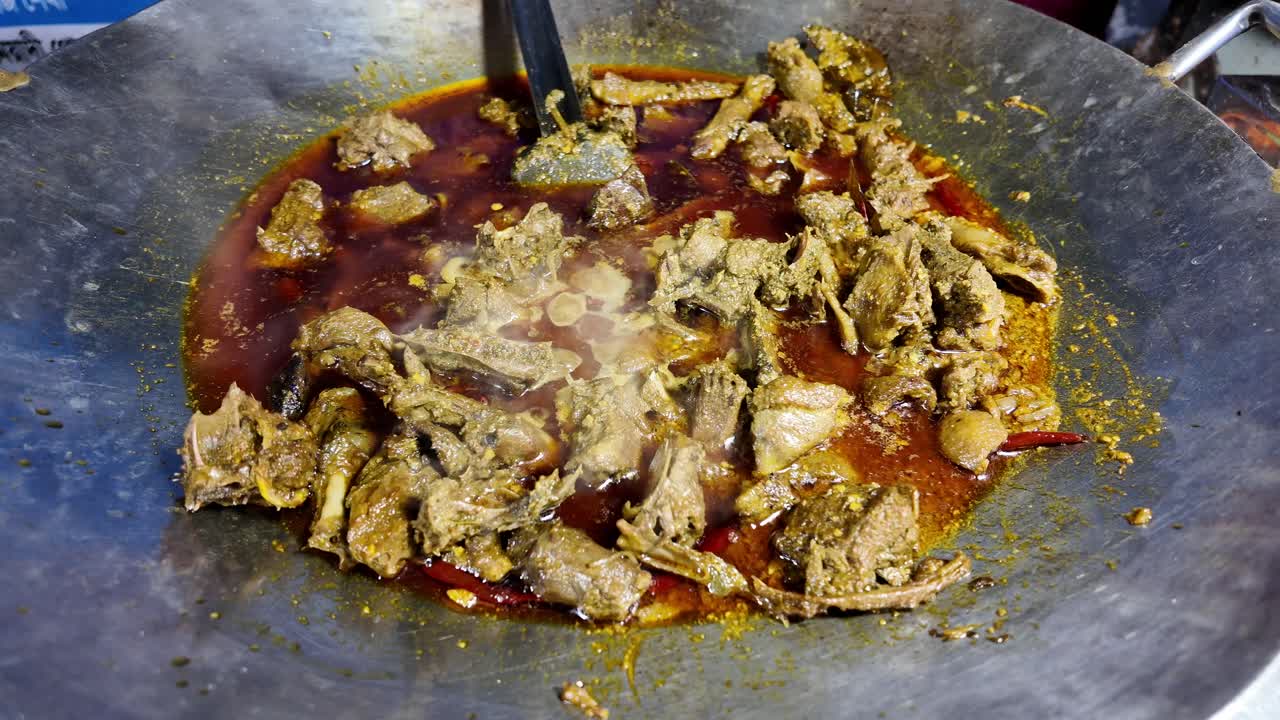 A meat dish is being cooked in a pan