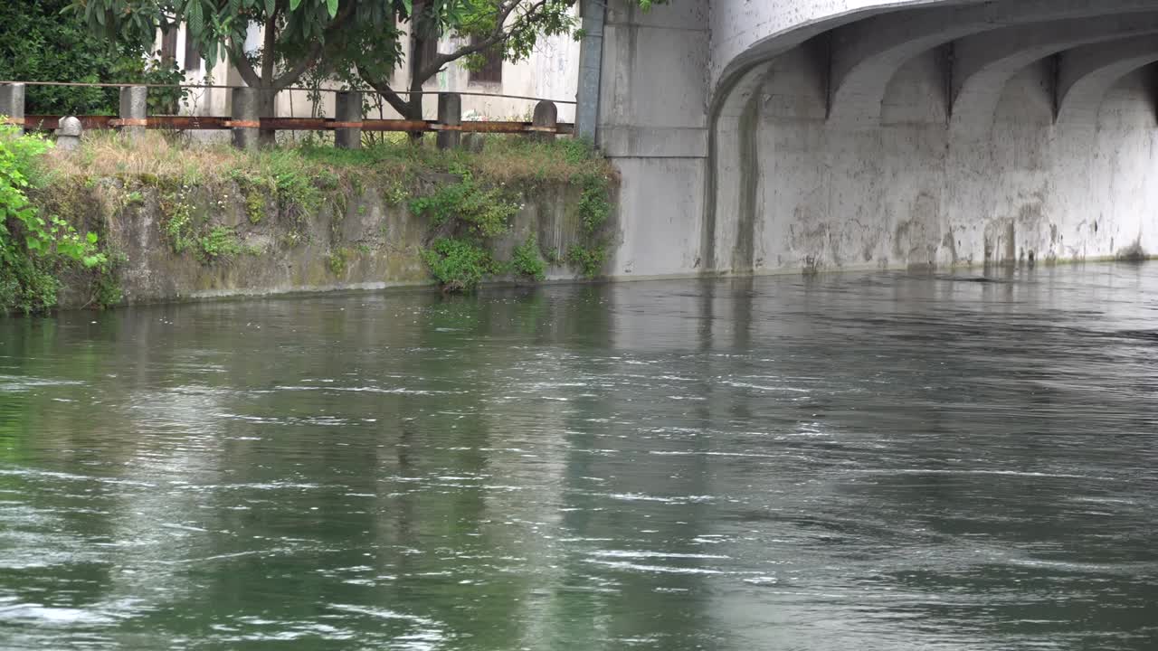 Flowing water in cold river via old stone bridge.