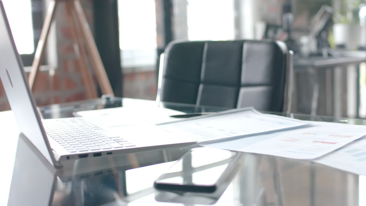 cerca del escritorio con teléfono inteligente, portátil y documentos en casa, oficina en cámara lenta