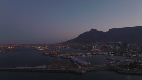 Aerial-view-of-harbour-in-industrial-neighbourhood-at-dusk.-Transport-of-cargo-and-logistics.-Cape-Town,-South-Africa