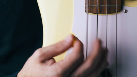 music teacher plays vertical guitar with metal bass stripes