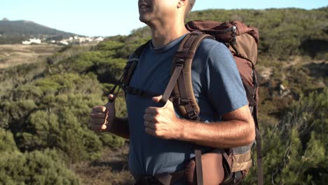 cropped shot of man wearing camping backpack