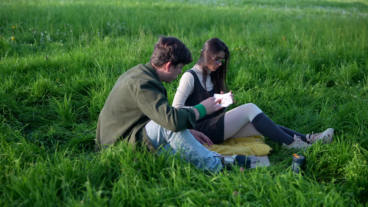 Couple Playing Cards in a Field