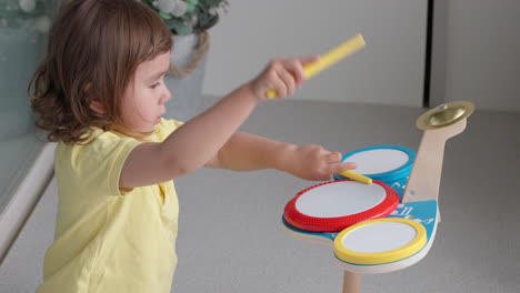 Child-Girl-Beats-With-Sticks-on-Toy-Drums-in-Slow-Motion---Close-up