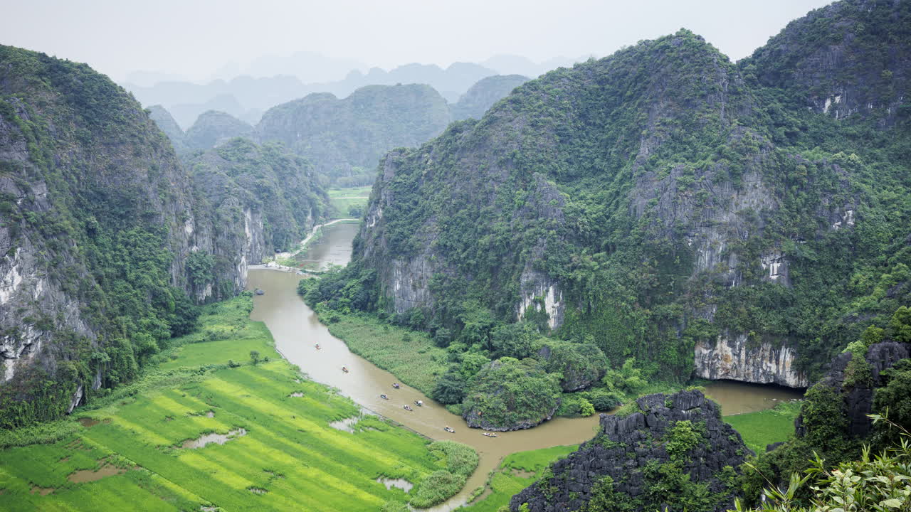 A static timelapse capturing Ninh Binh’s river with numerous tourist boats and the majestic limestone mountains as a stunning backdrop.