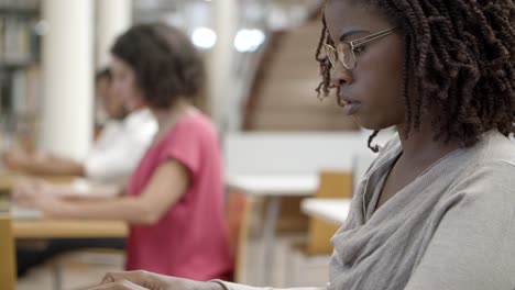 Side-view-of-pensive-student-working-with-laptop