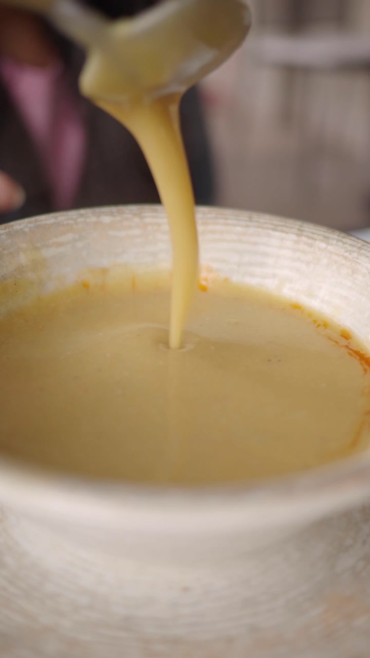 Close-up of a Spoon Stirring Thick Creamy Soup