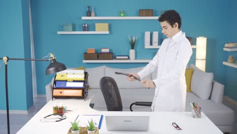 Dreamy-boy-at-home-sitting-at-desk-with-white-doctor-coat-and-stethoscope.