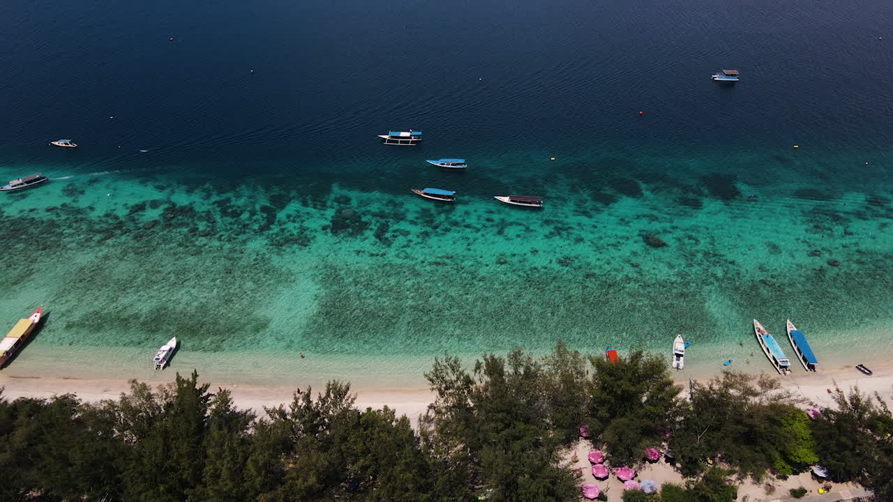 barcos en la orilla en una playa en bali, indonesia - toma aérea de drones