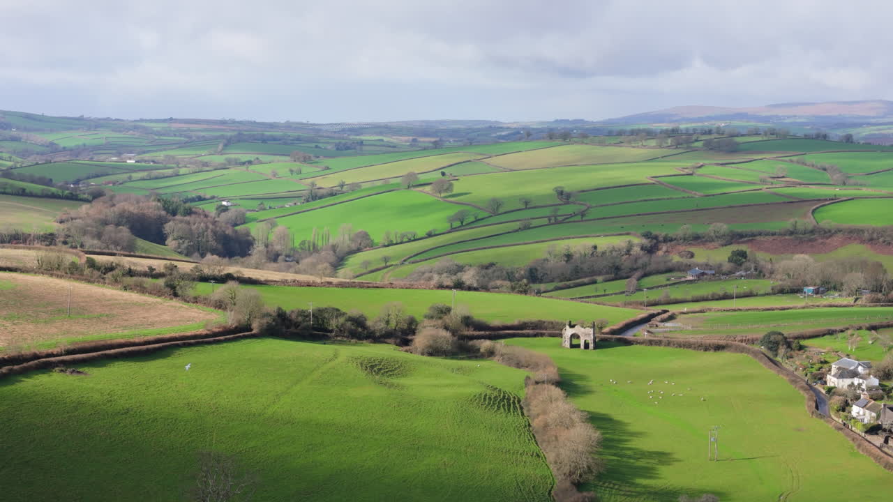 Cornworthy Priory old ruin nestled on rolling hill lush landscape, Devon, UK