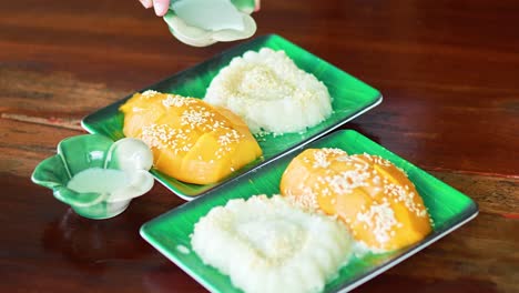 pouring coconut milk over mango sticky rice