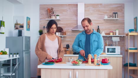 pareja cortando verduras frescas