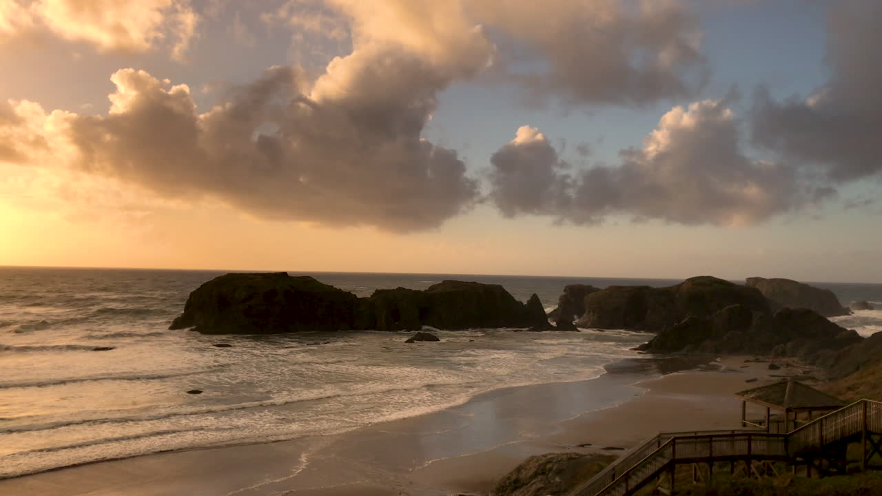 закат на пляже бандон с красивыми облаками и видом на океан и морские стеки