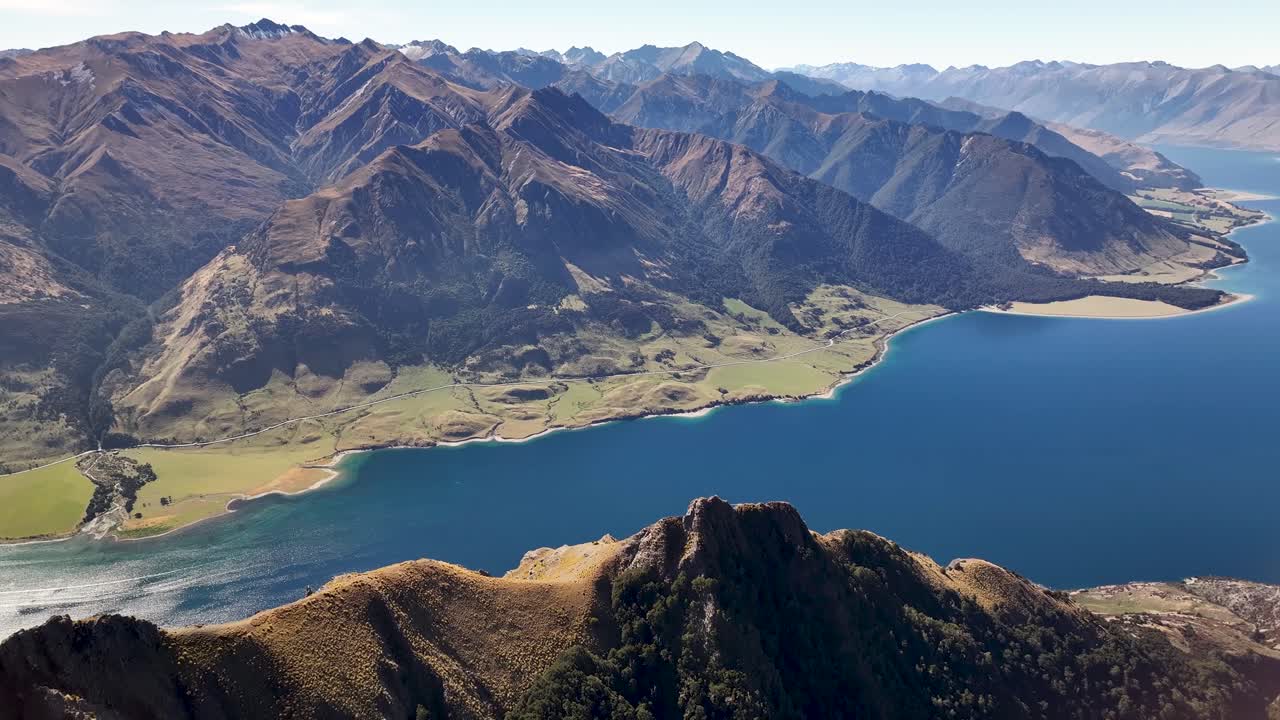 hermosa vista panorámica de los altos picos de las montañas y el lago hawea, un día soleado en otago, nueva zelanda
