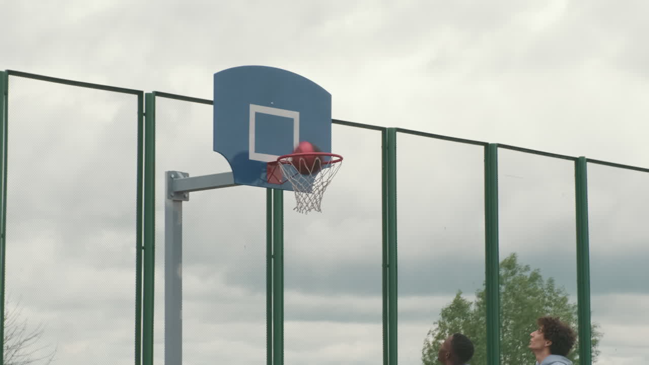 Men playing basketball outdoors
