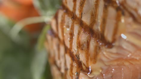 dressing pouring onto salad next to grilled salmon