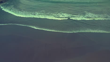 waves folding and touching the shores of baron beach aerial view, indonesia