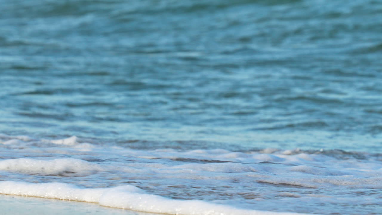 강력한 파도가 해변에 부히고, 그  거품이 공중에 스프레이됩니다.