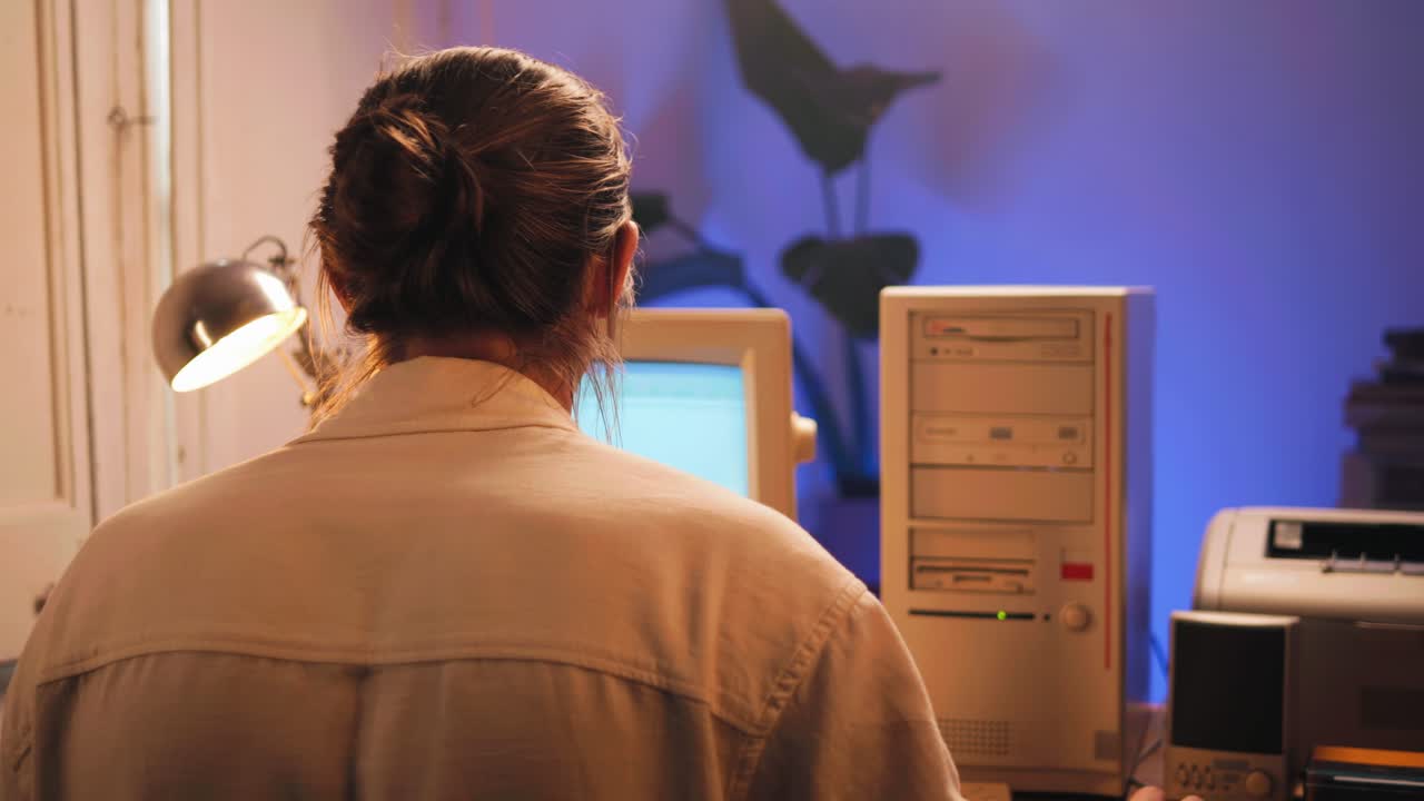 Man working and gaming on retro computer PC, IT engineer with vintage computer at home, using old fashion technology, close up of retro setup.