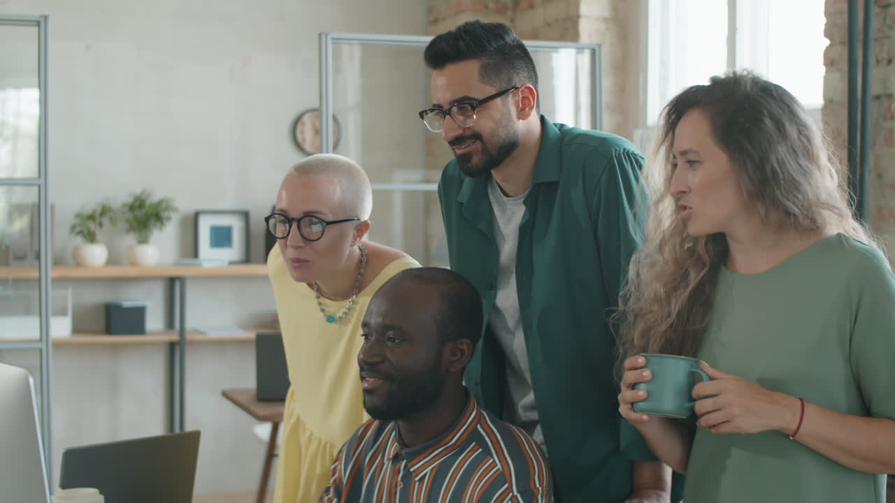 hombre negro en silla de ruedas discutiendo el proyecto en la computadora con el equipo de negocios