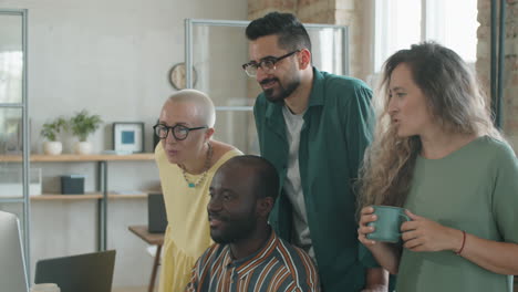 hombre negro en silla de ruedas discutiendo el proyecto en la computadora con el equipo de negocios