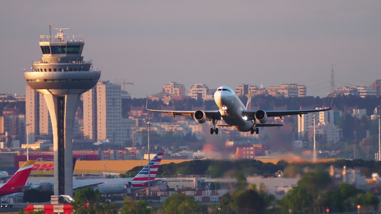 MADRID, SPAIN - APRIL 1, 2025: An Iberia airliner takes off from Adolfo Suarez Madrid-Barajas Airport during sunrise. The aircraft's landing gear is still extended, and the Iberia tail colors are clearly visible. Other airline tails, including American Airlines, are seen in the background along with