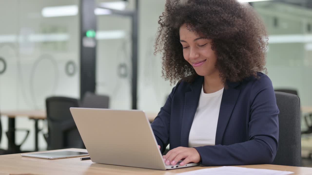 Young African Businesswoman with Laptop Shaking Head in Approval, Yes