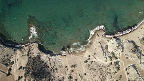 Slowly-circling-toward-rocky-Mediterranean-coastline-with-turquoise-blue-water