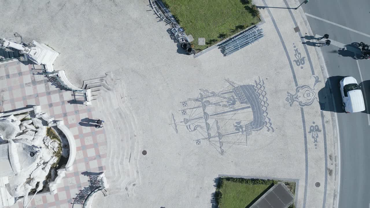 los autos circulan a su alrededor, mientras que detrás de la estatua está el parque eduardo vii, y al frente está la avenida principal de la ciudad, avenida da liberdade