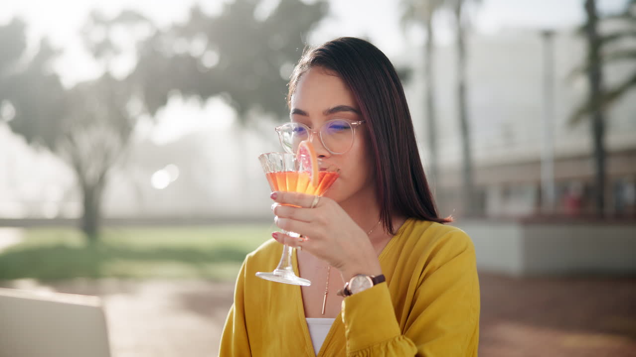 Woman drinking cocktail outdoors