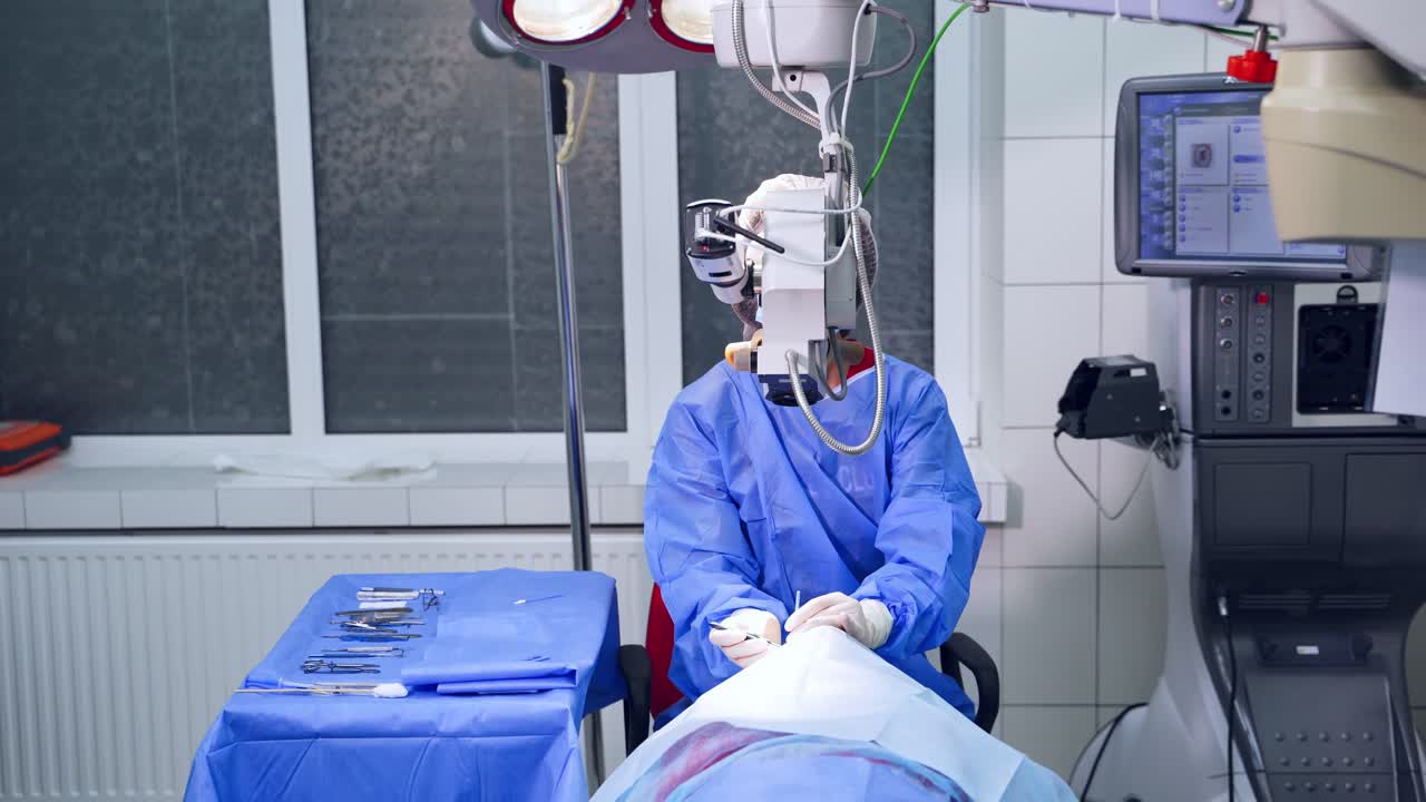 Surgeon Using Operating Microscope During Work. Video from the side. Selective video focus on special ophtalmology Modern equipment and doctor's work.