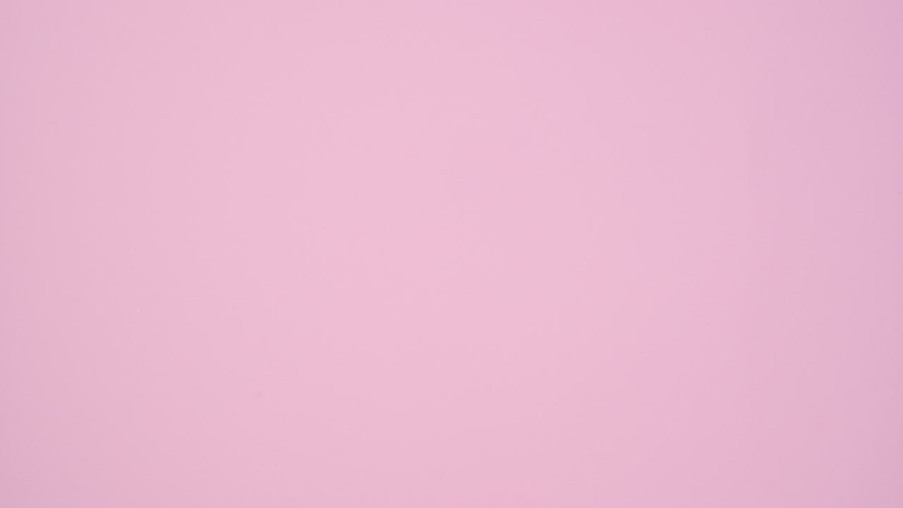 Pastel pink gift with ribbon passing on right side of pastel pink theme. Stop motion