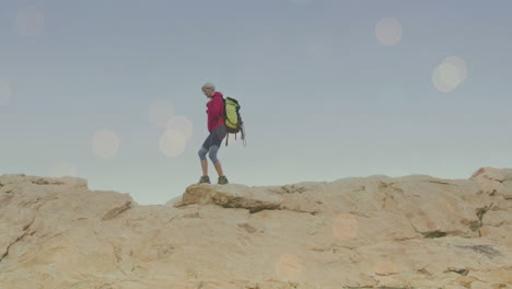 animación de puntos de luz sobre mujer caucásica caminando en las montañas