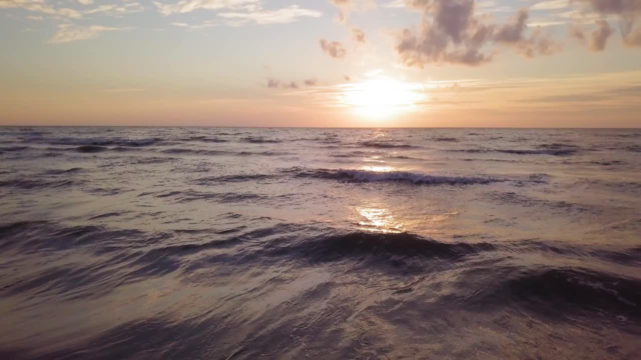 Beautiful aerial establishing view of Baltic sea coast on a sunny evening, sunset, golden hour, beach with white sand, coastal erosion, climate changes, low wide angle drone shot moving backward