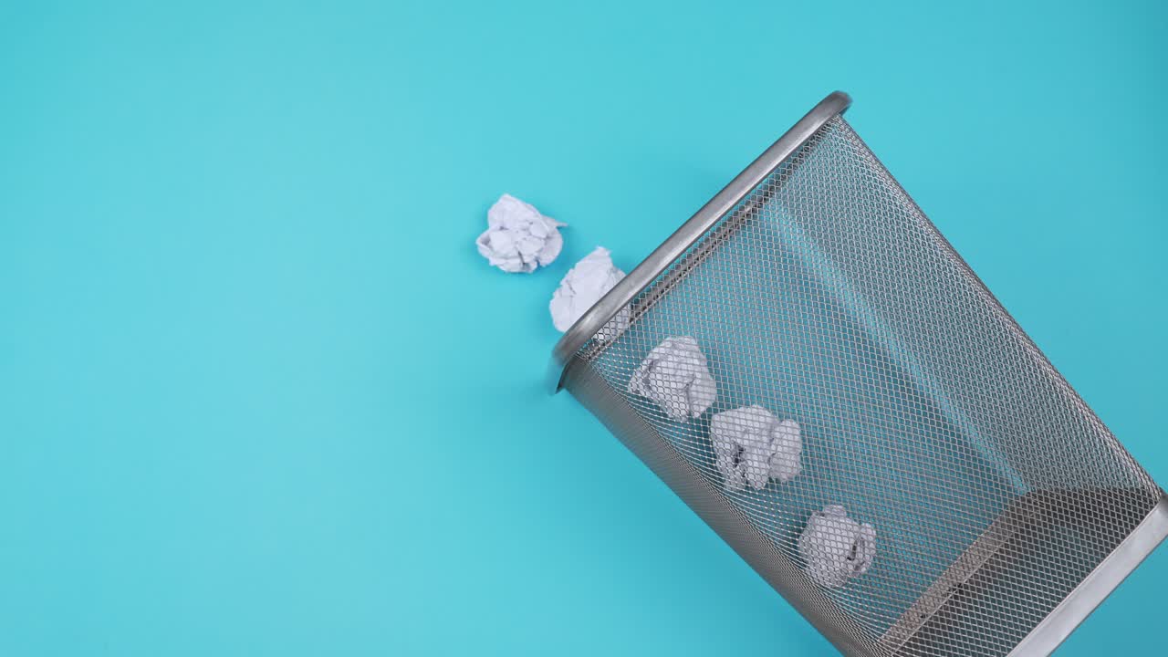 um cesto de lixo de escritório vazio cheio de papéis de lixo.