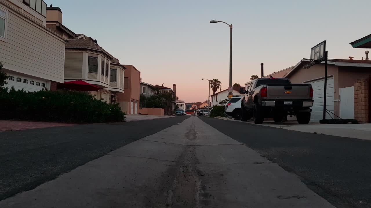 Low dolly shot along center of street by the beach during sunset in Ventura, California, USA
