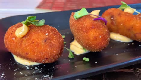 Traditional-Spanish-croquettes,-tapas-in-Marbella-Spain,-tasty-and-crispy-breaded-starter-dish-in-a-restaurant,-4K-shot